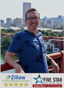 A person standing on a bridge, smiling as they take in the city skyline. Below, logos and ratings for Zillow 5-Star Premier Agent and Five Star Real Estate Agent assure you can sell your Portland home fast with top-tier assistance.